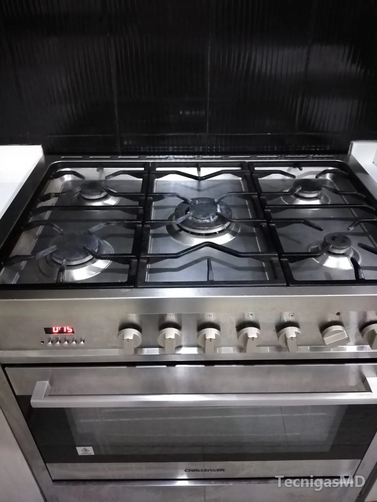 Estufa con horno a gas Challenger en acero inoxidable, con cinco quemadores, parrillas negras y reloj digital encendido