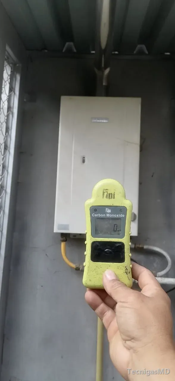 Detector de monóxido de carbono con lectura en cero frente a un calentador a gas de paso instalado dentro de un gabinete